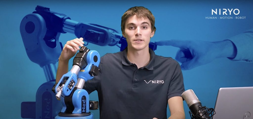 Personne montrant différents moteurs sur un robot collaboratif