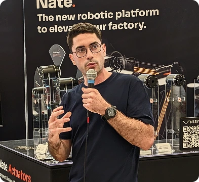 Marc-Henry Frouin, CEO of Niryo, presenting a Nate robotic platform at an industry trade show.